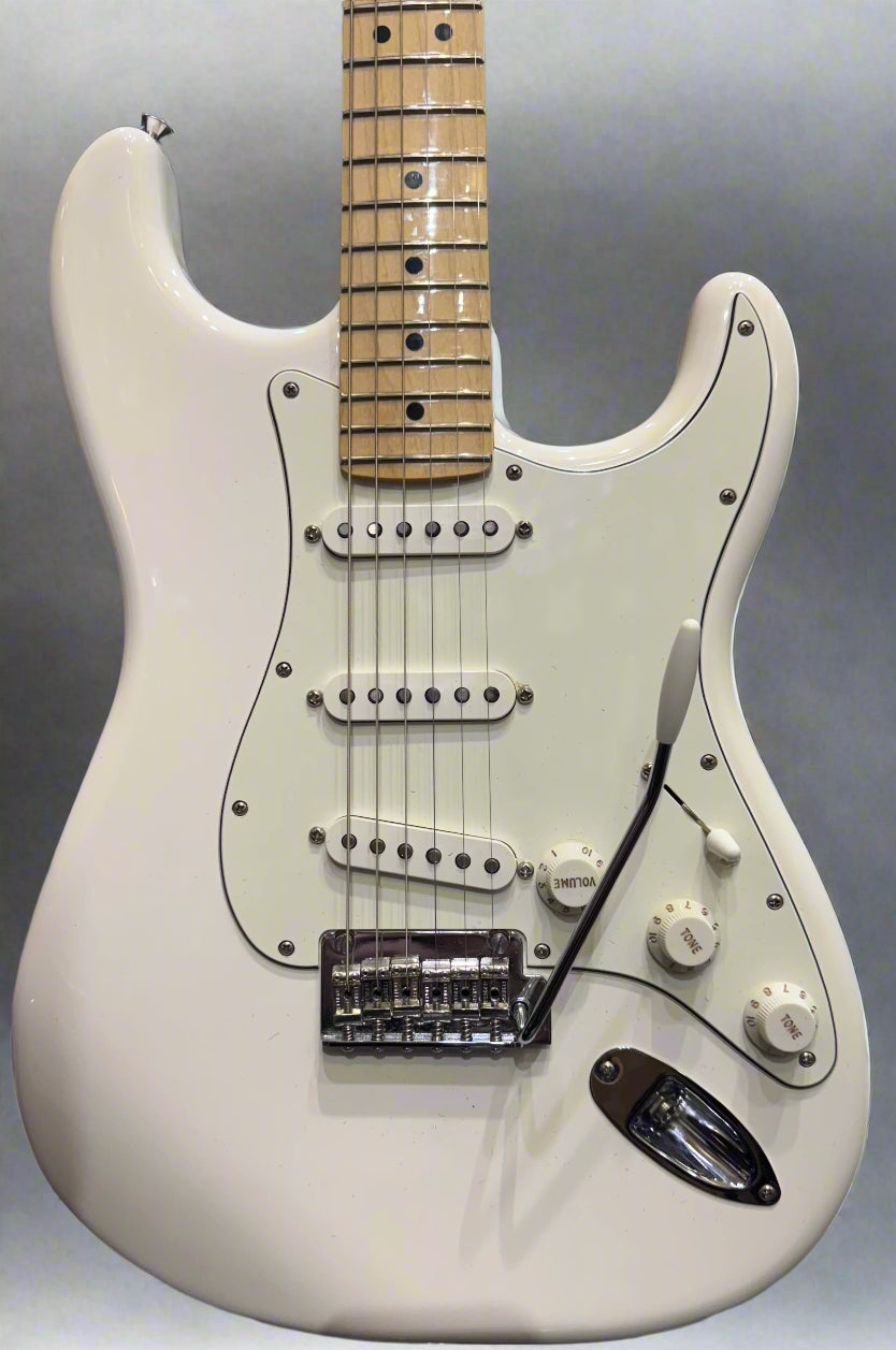 White electric guitar with a worn finish in a music store setting
