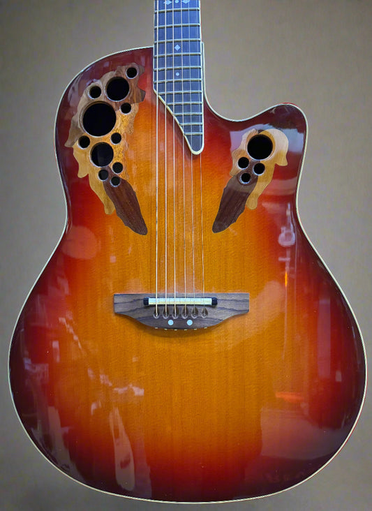 Acoustic guitar with a sunburst finish on a wooden background