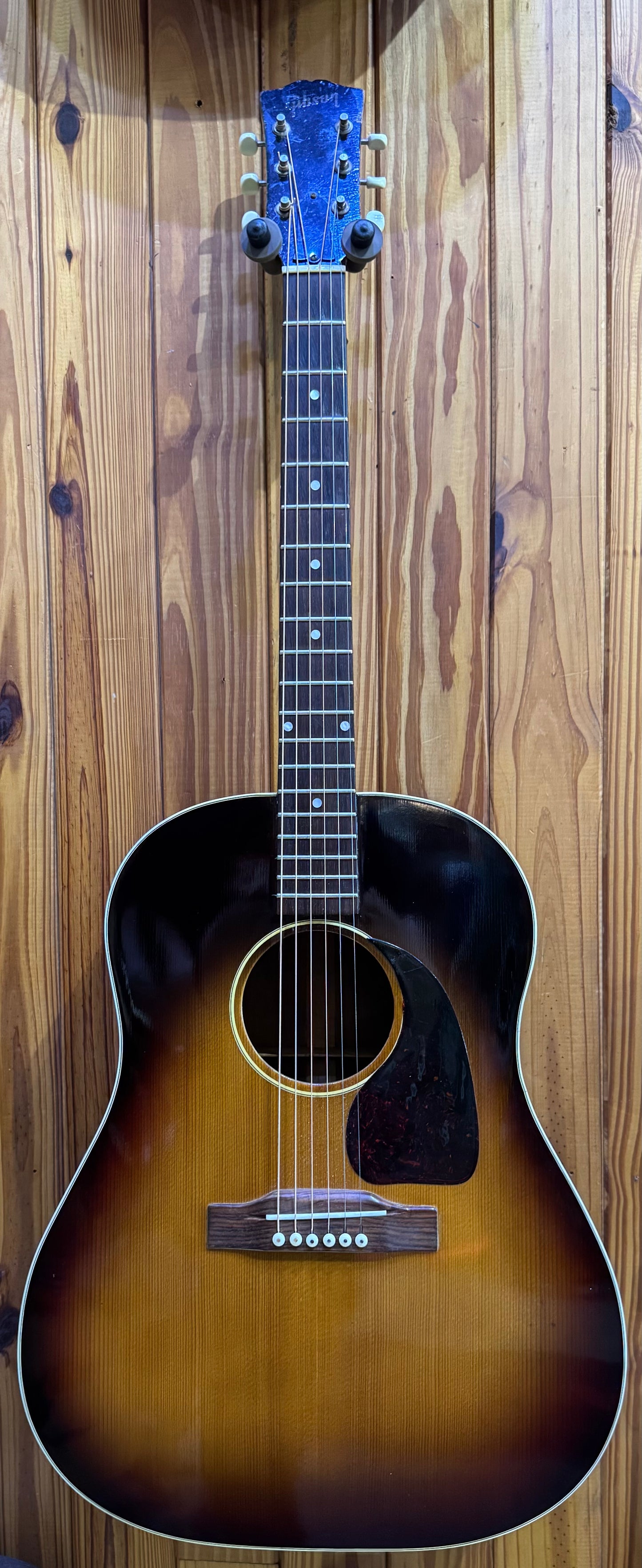 Acoustic guitar with a sunburst finish against a wooden background