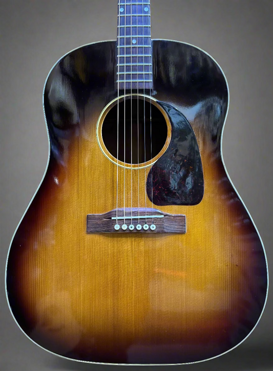Acoustic guitar with a sunburst finish on a wooden background