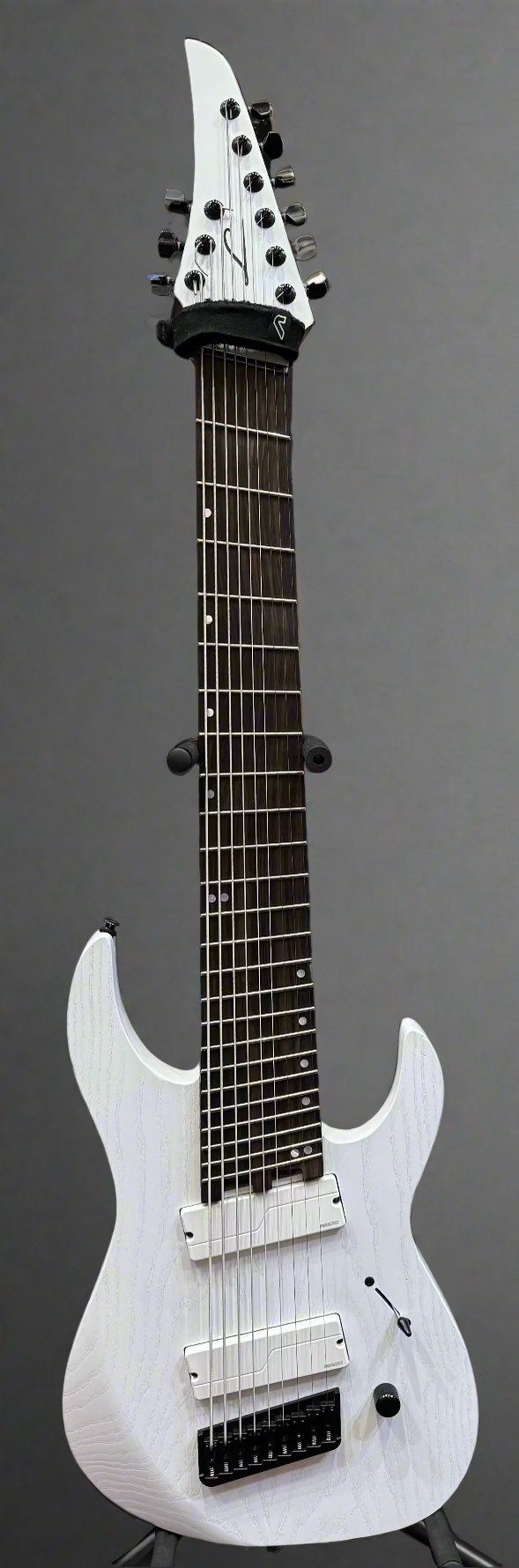 White electric guitar with amplifier in the background
