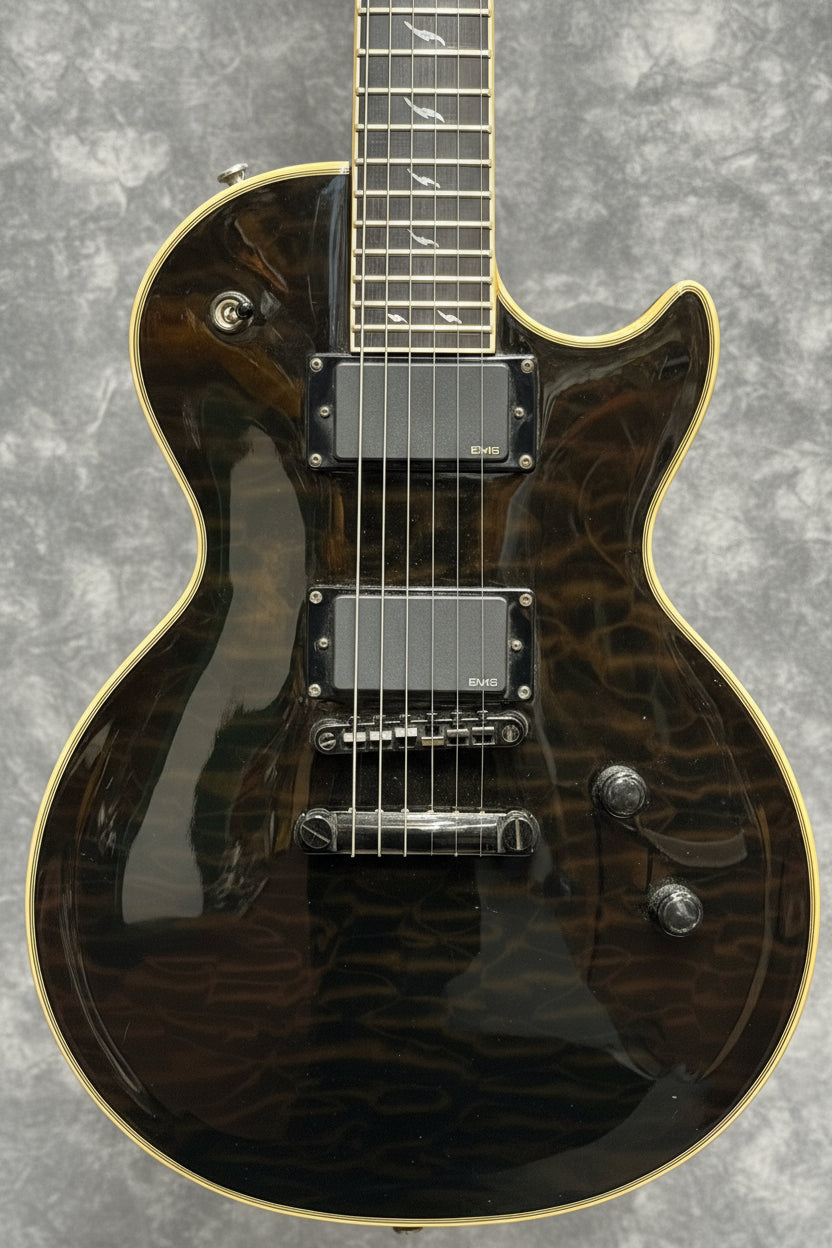 Black electric guitar with a textured finish on a wooden wall background