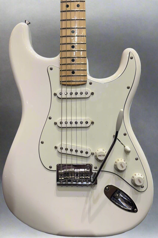 White electric guitar with a worn finish in a music store setting