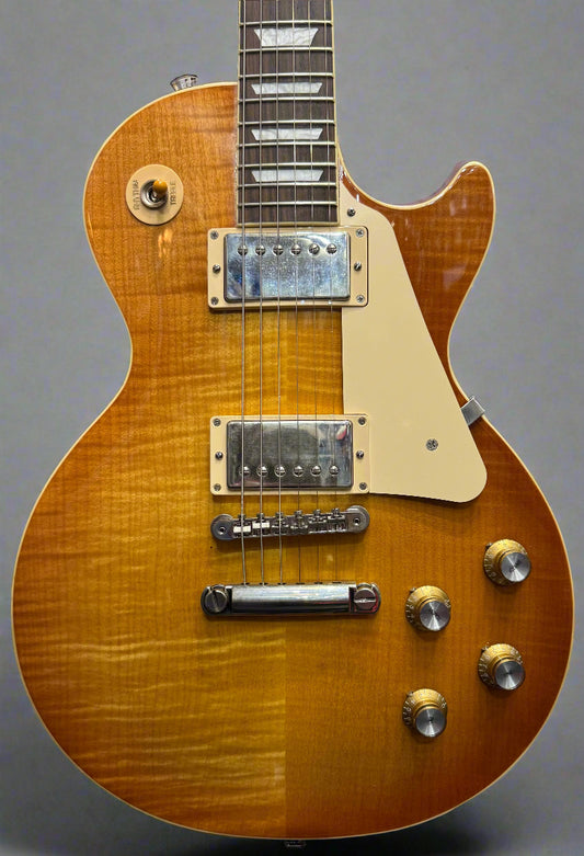 Gibson Les Paul guitar with a sunburst finish in a store setting.
