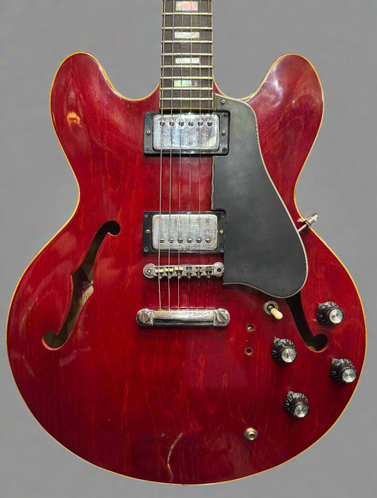 Red electric guitar with a black pickguard in a store setting