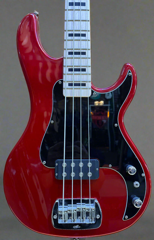 Red electric bass guitar on a wooden background