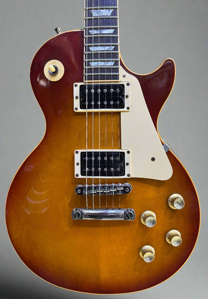 Gibson Les Paul guitar with a sunburst finish on a wooden background
