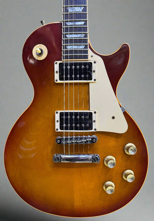 Gibson Les Paul guitar with a sunburst finish on a wooden background