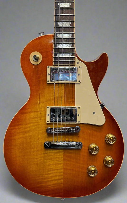 Gibson Les Paul electric guitar with a sunburst finish in a music store setting.