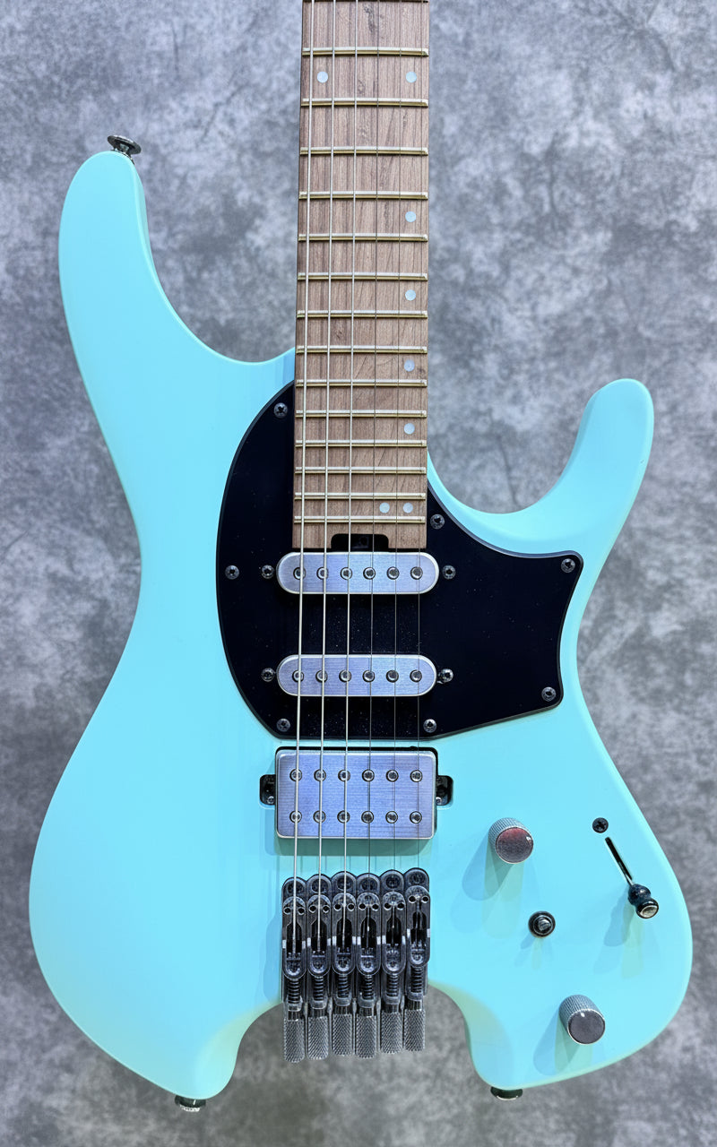 Light blue electric guitar on a wooden background