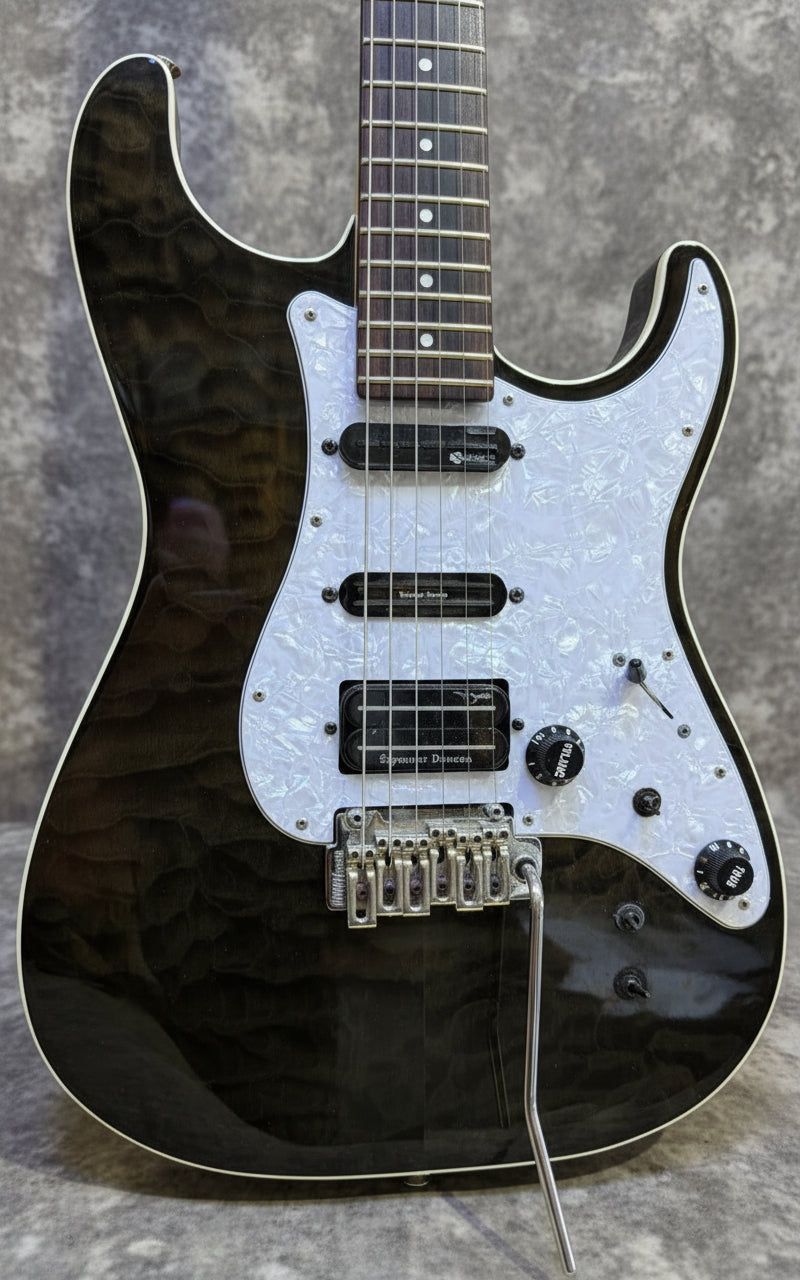 Black electric guitar with a white pickguard on a wooden background