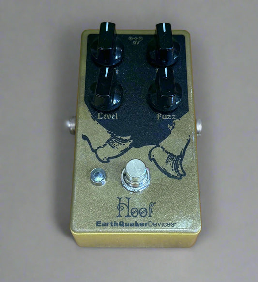 Guitar effects pedal with 'Hoof' and 'EarthQuaker Devices' branding on a wooden surface.
