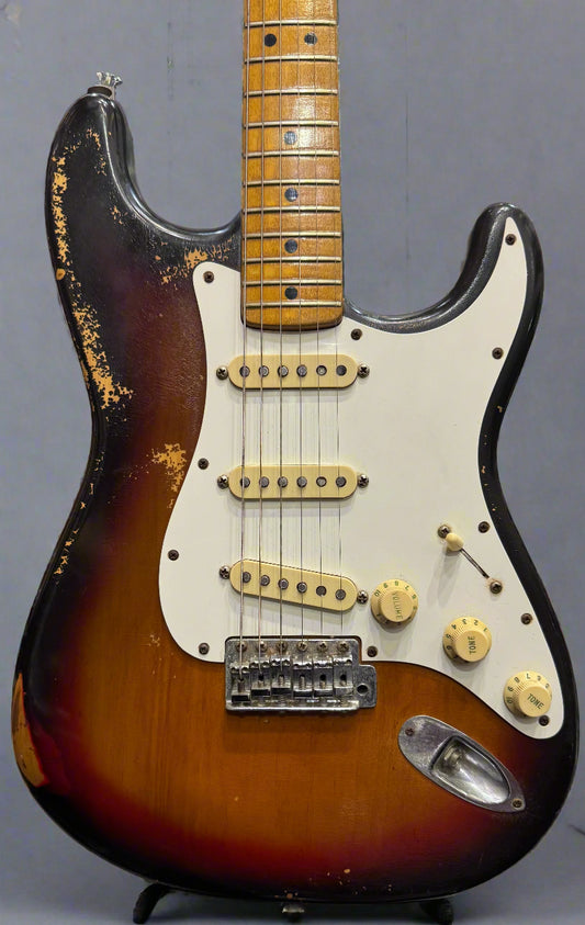 Fender Stratocaster guitar with a sunburst finish on a stand.