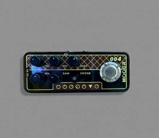 Guitar effects pedal with control knobs on a wooden surface