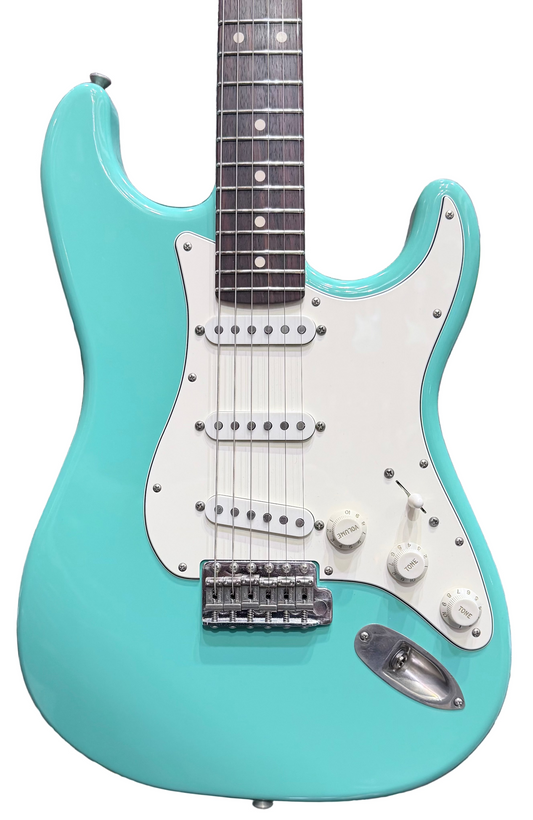 Turquoise electric guitar with white pickguard against a background of other guitars