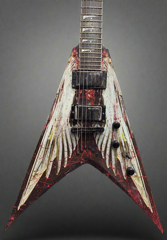 Distressed electric guitar with a unique design in front of a wall of other guitars.