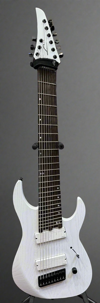 White electric guitar with amplifier in the background