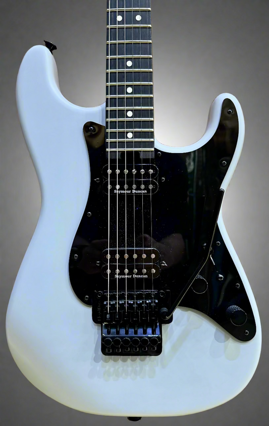 Grey electric guitar with black pickguard on a wooden background
